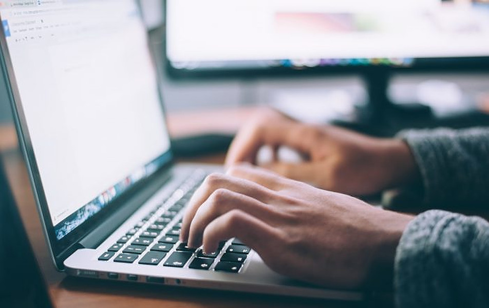 Picture of a laptop with a person typing on it